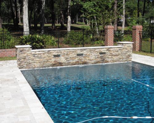 Madison custom pool design with stylish curves, blue water, and stone decking.