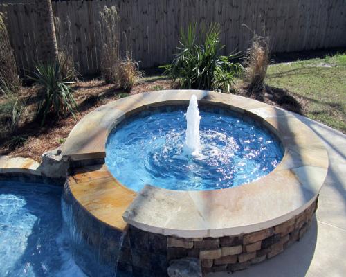 Madison swimming pool design with stylish curves, blue water, and stone decking.