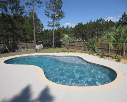 Monticello swimming pool design with premium outdoor features and stone deck.