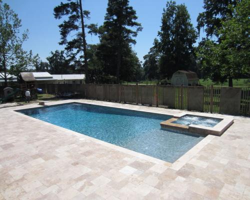 Valdosta swimming pool design with blue water and custom stone deck for luxury.
