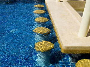 Mystic Pools custom gunite pool with decorative submerged stepping stones leading to a stone coping ledge and column feature